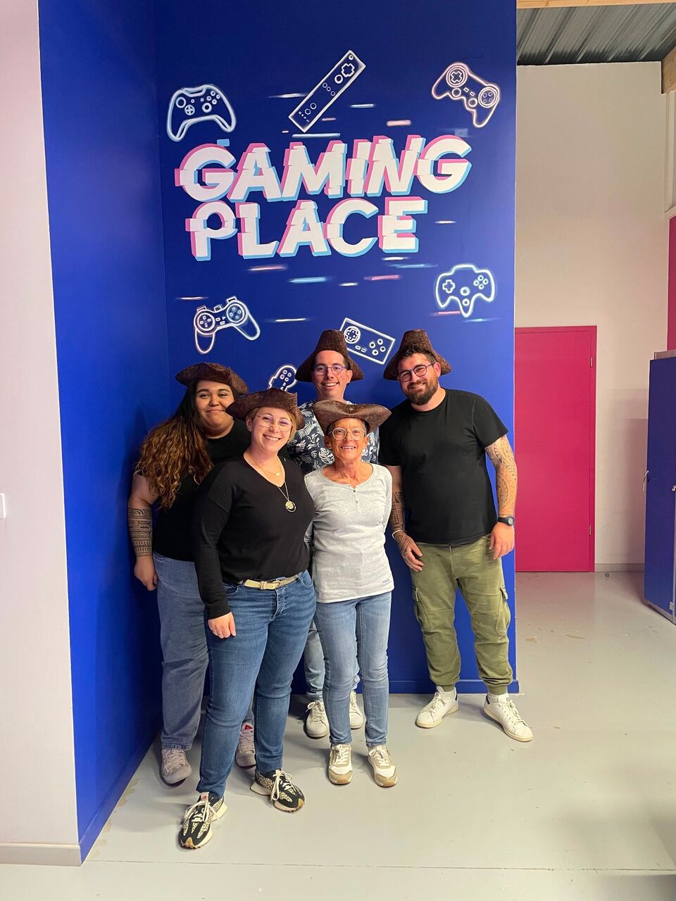 Groupe avec chapeaux de pirate devant la fresque Gaming Place